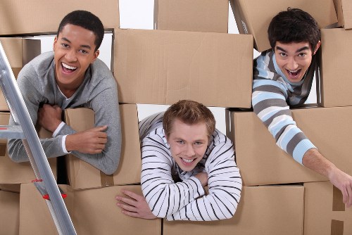 Movers carrying furniture through a Sutton property